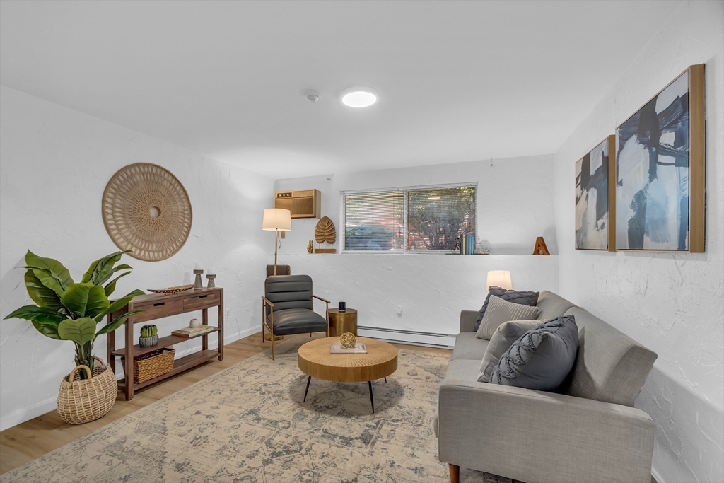 208 Swanson Road, Unit 526 Boxborough, MA 01719 - Photo 5 of 23 a living room with furniture a mirror and a potted plant