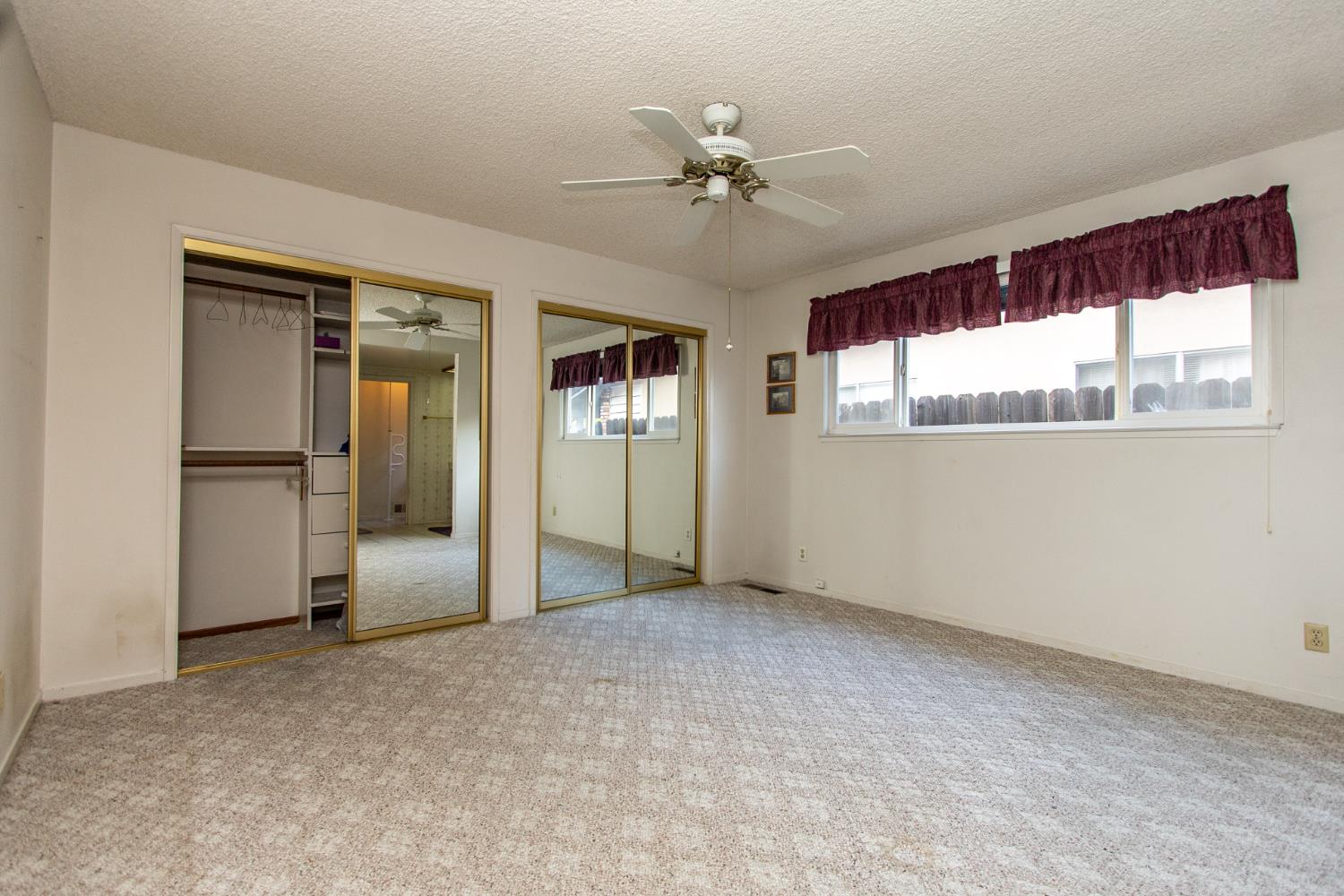 1540 Switzer Court Modesto, CA 95350 - Photo 16 of 43 an empty room with chandelier fan and windows