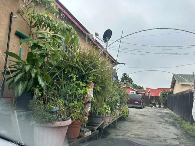a backyard of a house with plants and outdoor seating