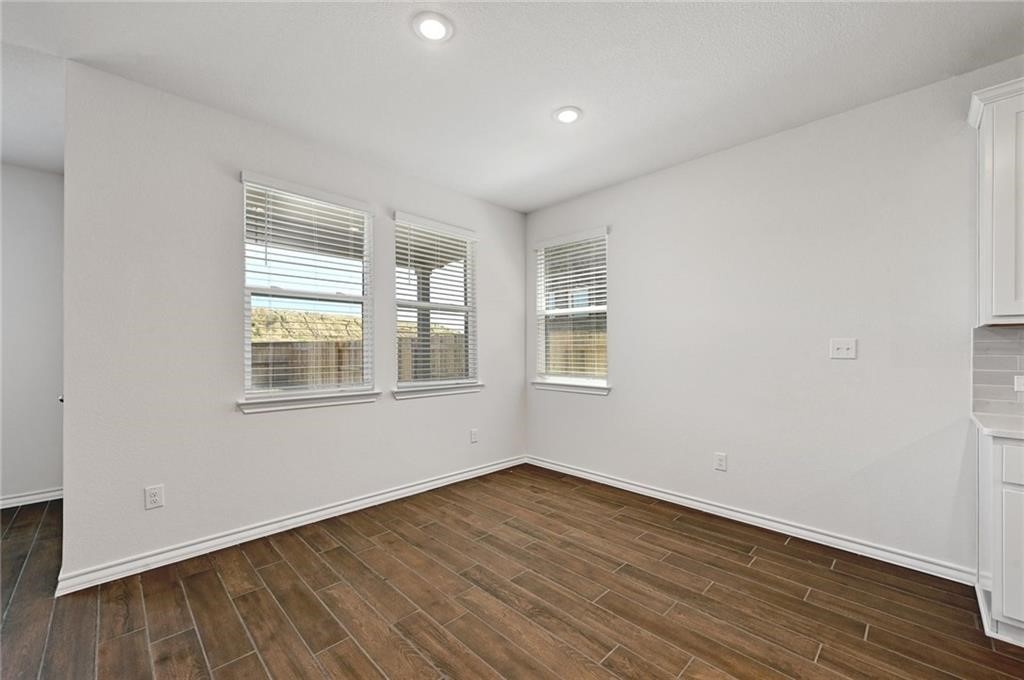 806 Pepperbark Loop Buda, TX 78610 - Photo 12 of 39 an empty room with wooden floor and windows