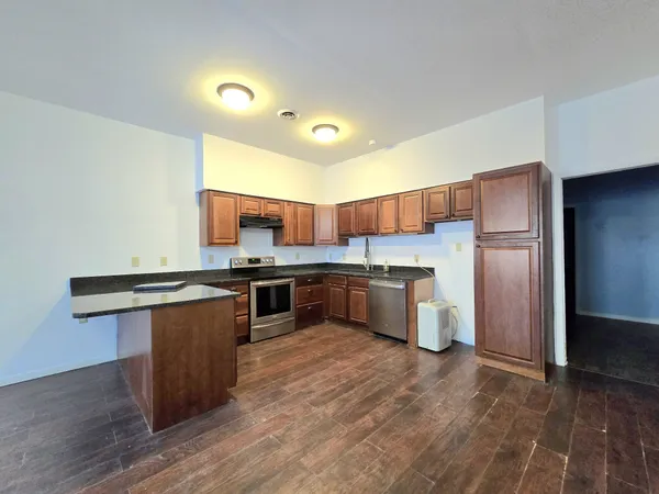 a kitchen with stainless steel appliances granite countertop a stove a sink dishwasher and a refrigerator