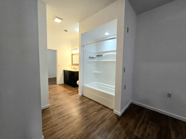 a view of empty room with wooden floor and window