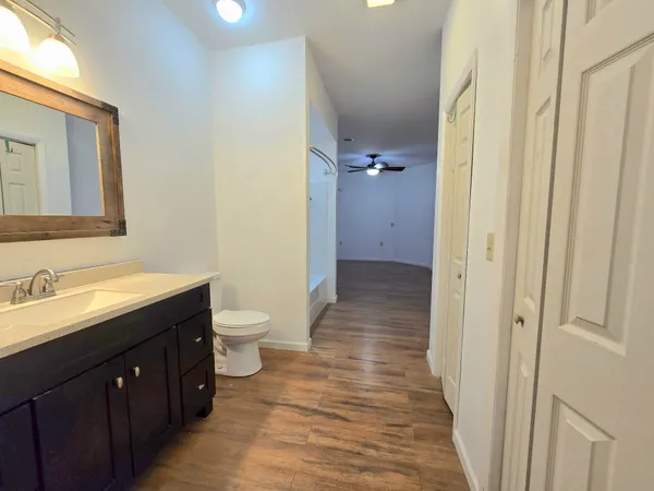 a spacious bathroom with a double vanity sink a toilet and a mirror