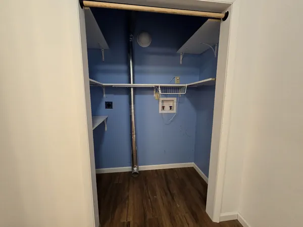a view of walk in closet with wooden floor