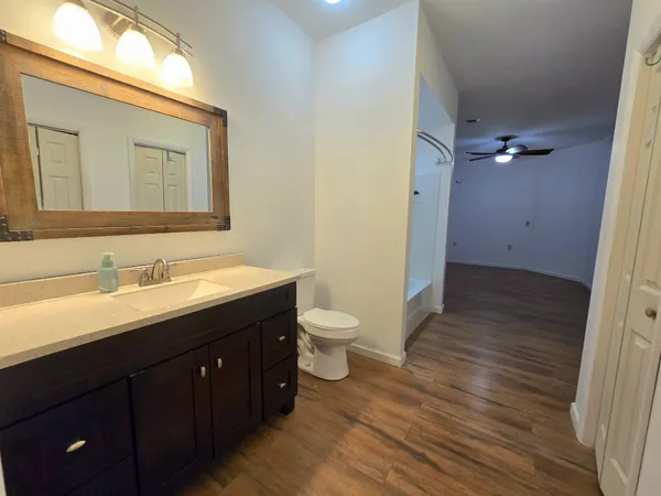 a bathroom with a granite countertop sink toilet a mirror and a shower