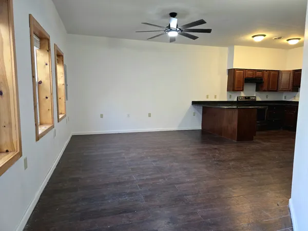a view of room with a flat screen tv and kitchen view