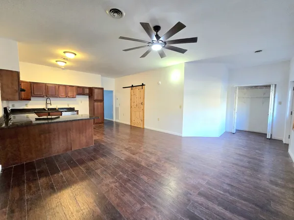 a kitchen with kitchen island white cabinets and black stainless steel appliances attached with living room