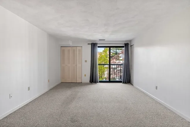 an empty room with windows and a sink