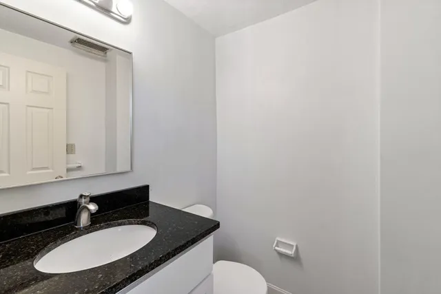 a bathroom with a granite countertop sink and a mirror
