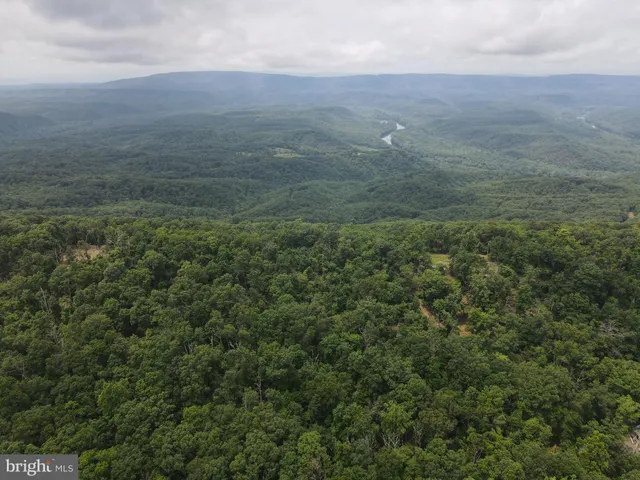 an aerial view of house with yard and mountain in back