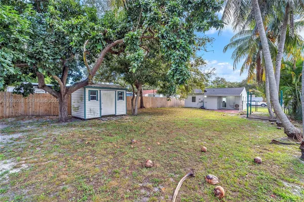 a view of a house with a backyard and a tree