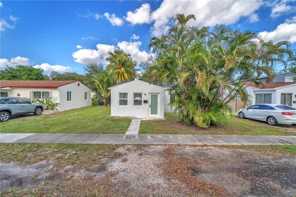 a view of a house with a yard and tree s