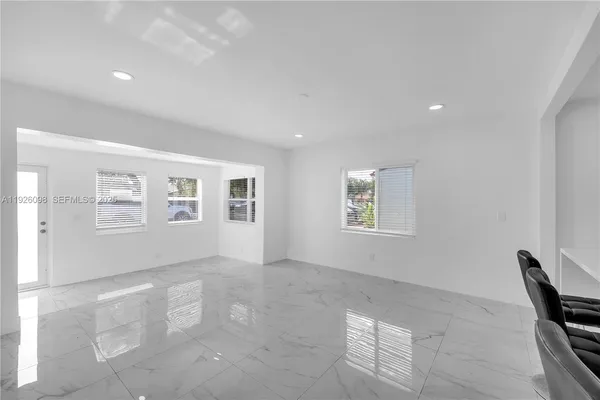 a kitchen with stainless steel appliances kitchen island granite countertop a dining table and chairs