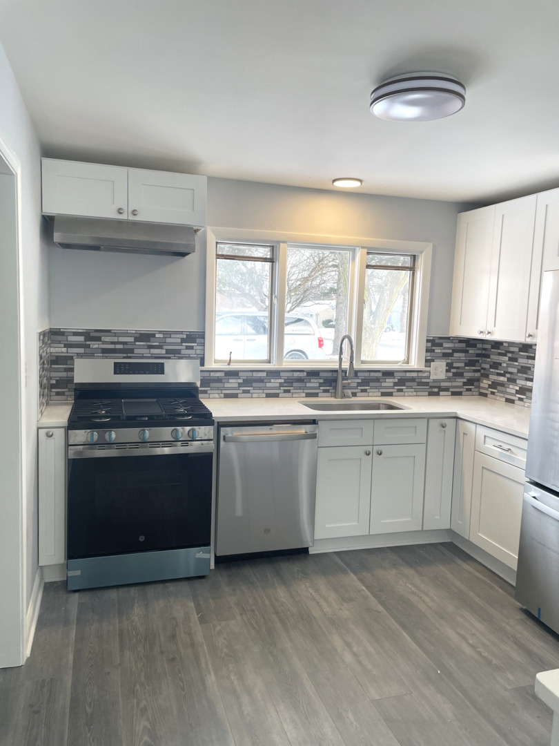 205 Fairview Boulevard Rockford, IL 61107 - Photo 6 of 12 a kitchen with granite countertop a stove a sink and a microwave