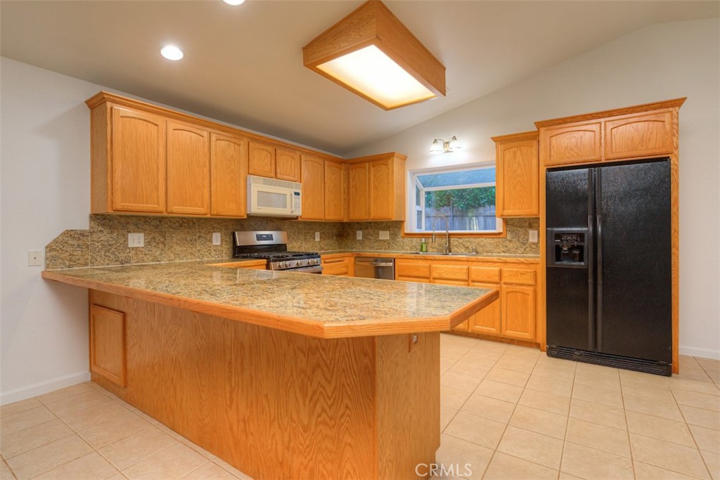 14503 Colter Way Magalia, CA 95954 - Photo 14 of 42 a kitchen with stainless steel appliances granite countertop a sink refrigerator and cabinets