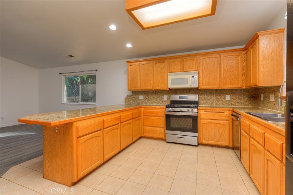 14503 Colter Way Magalia, CA 95954 - Photo 16 of 42 a kitchen with stainless steel appliances granite countertop a stove a sink and a refrigerator