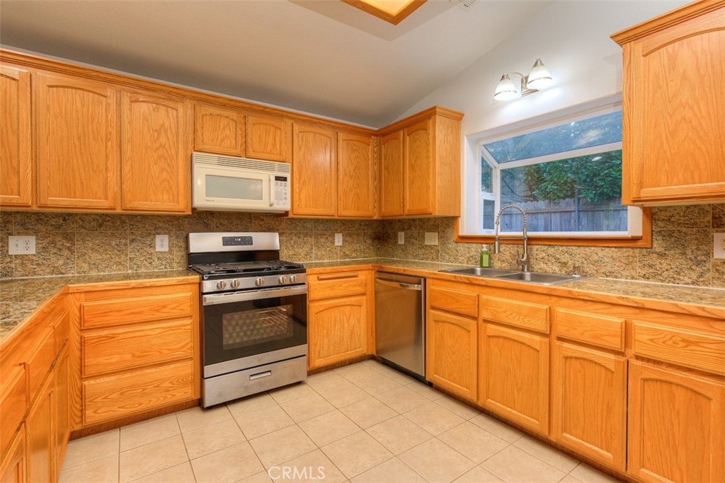 14503 Colter Way Magalia, CA 95954 - Photo 17 of 42 a kitchen with stainless steel appliances granite countertop a stove a sink and a microwave