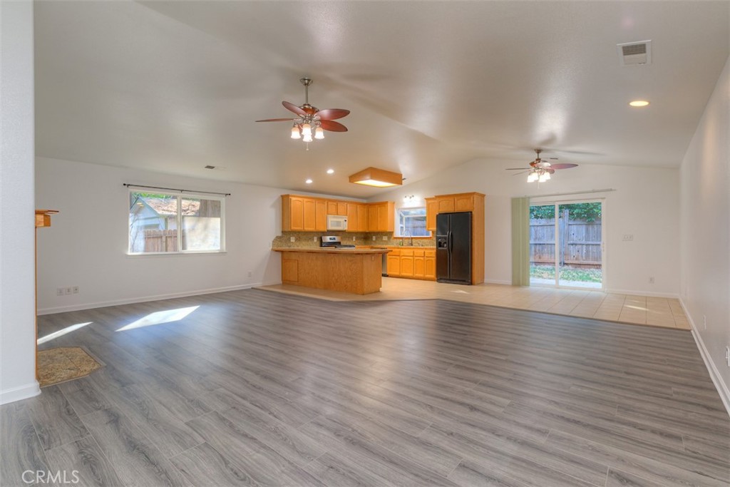 14503 Colter Way Magalia, CA 95954 - Photo 6 of 42 a view of an empty room with a kitchen and wooden floor
