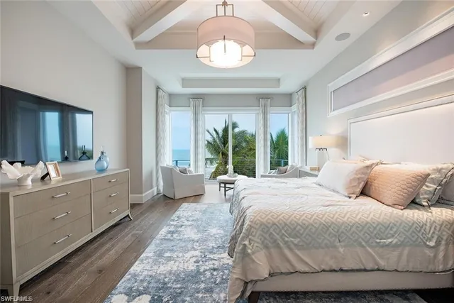 a spacious bedroom with a large bed and a chandelier