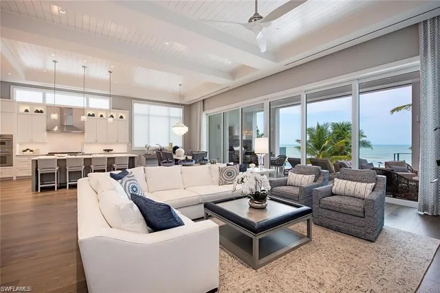 a living room with furniture kitchen view and a large window