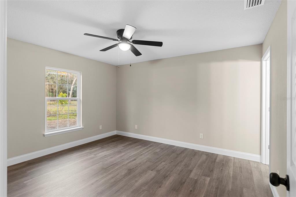 603 Moose Lodge Road, Unit A Bartow, FL 33830 - Photo 30 of 45 an empty room with wooden floor fan and windows