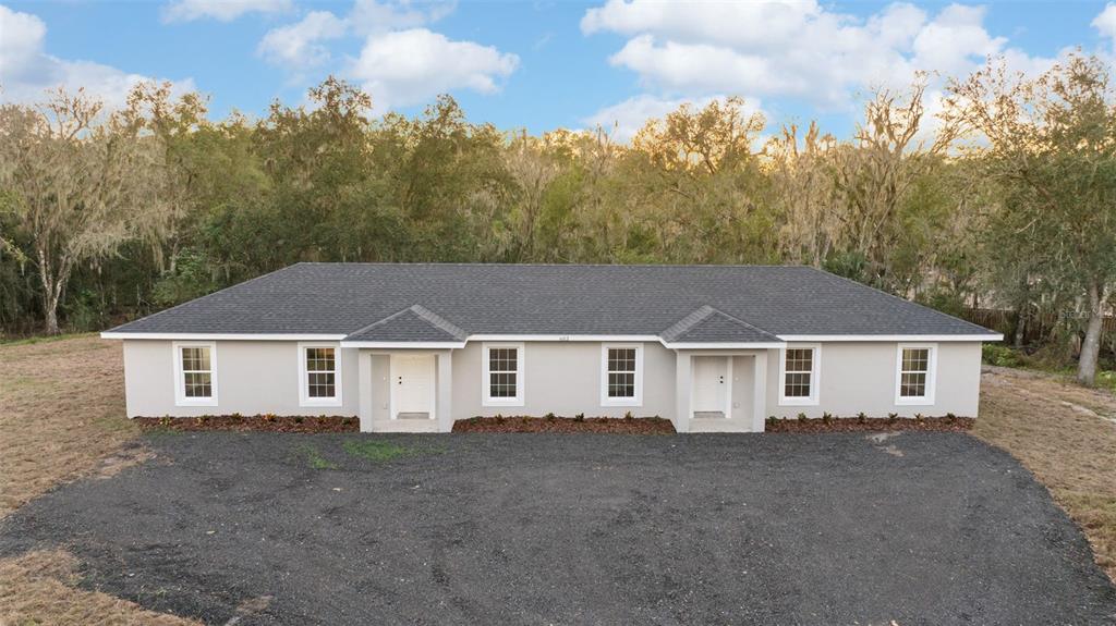 603 Moose Lodge Road, Unit A Bartow, FL 33830 - Photo 42 of 45 a view of a white house next to a yard with large trees
