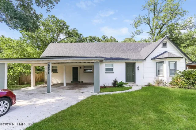a front view of a house with a garden and plants