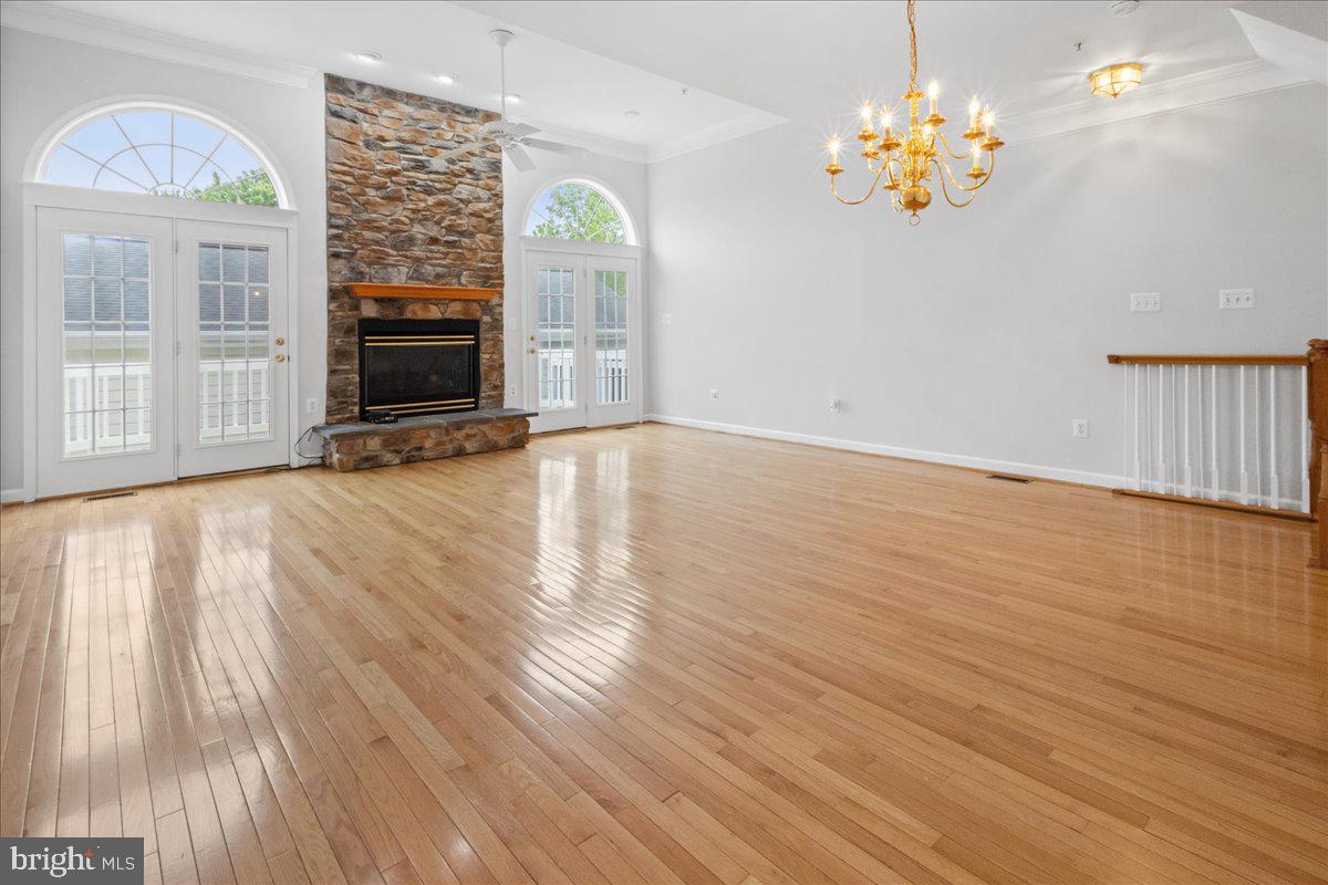 3618 Sprigg Street South Frederick, MD 21704 - Photo 22 of 37 an empty room with wooden floor fireplace and chandelier