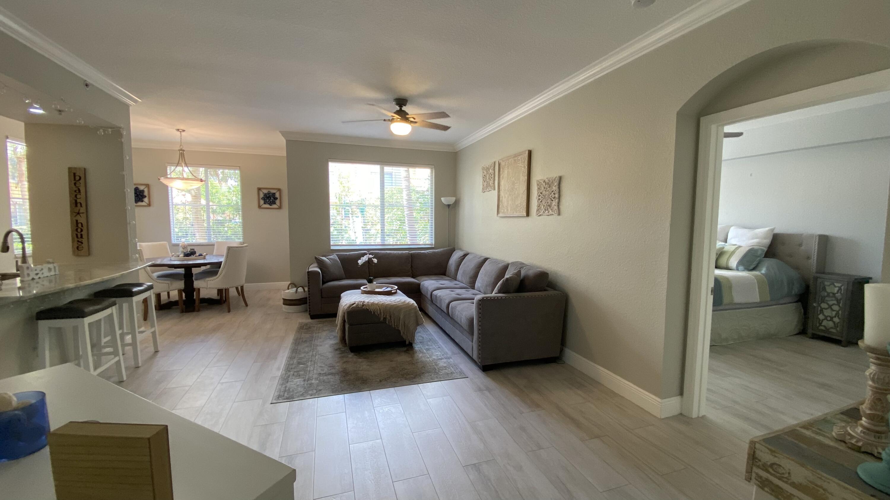 11024 Legacy Drive, Unit 104 Palm Beach Gardens, FL 33410 - Photo 1 of 26 a living room with furniture and a wooden floor