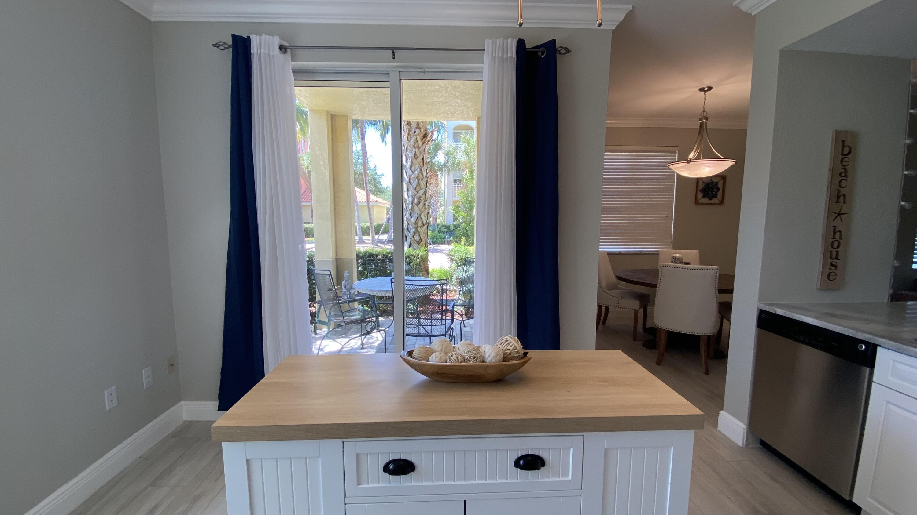 11024 Legacy Drive, Unit 104 Palm Beach Gardens, FL 33410 - Photo 11 of 26 a view of a kitchen area with furniture and large window
