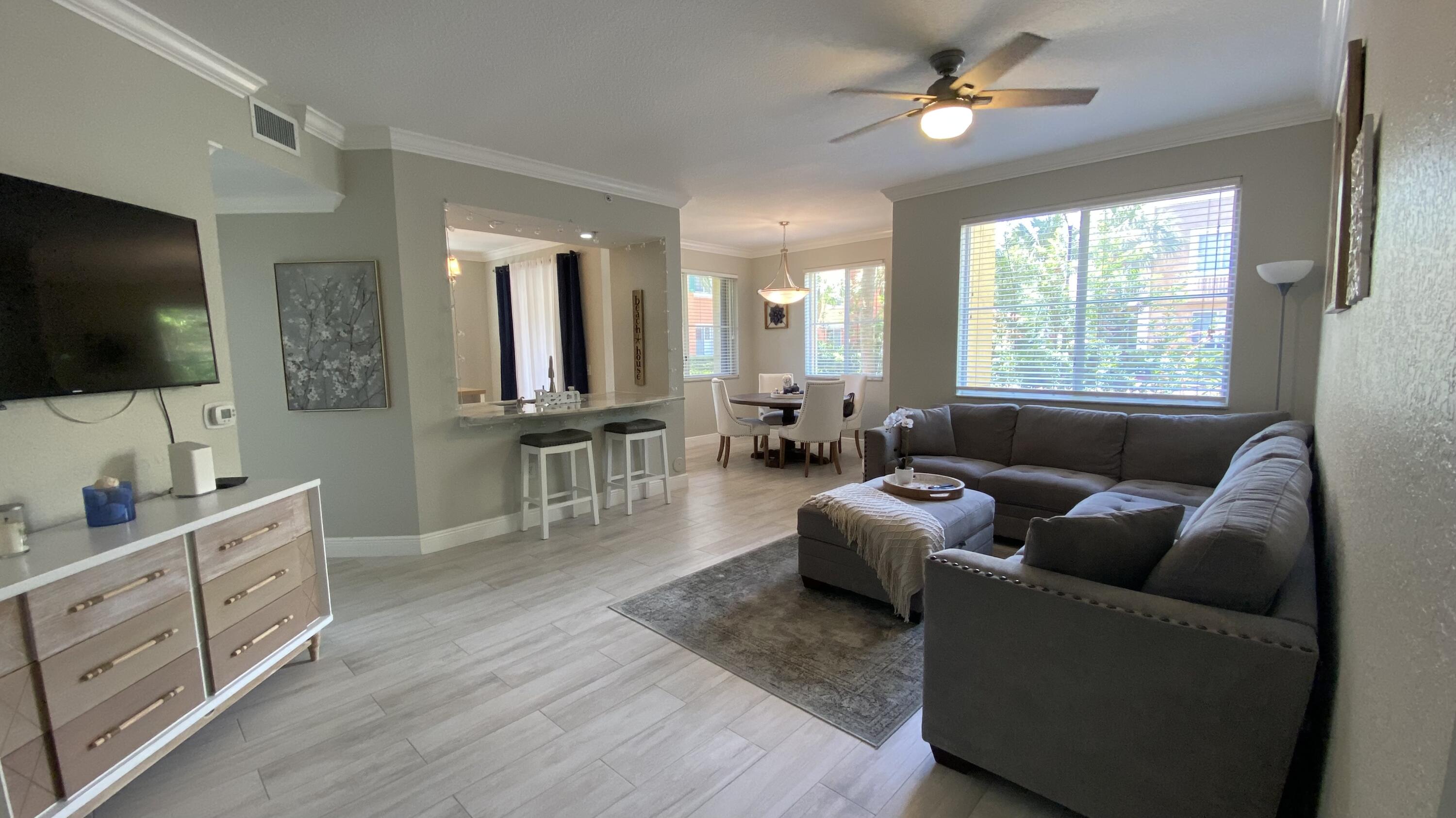 11024 Legacy Drive, Unit 104 Palm Beach Gardens, FL 33410 - Photo 2 of 26 a living room with furniture and a flat screen tv