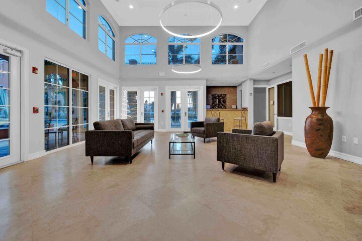 11024 Legacy Drive, Unit 104 Palm Beach Gardens, FL 33410 - Photo 21 of 26 a living room with furniture a flat screen tv and a large window