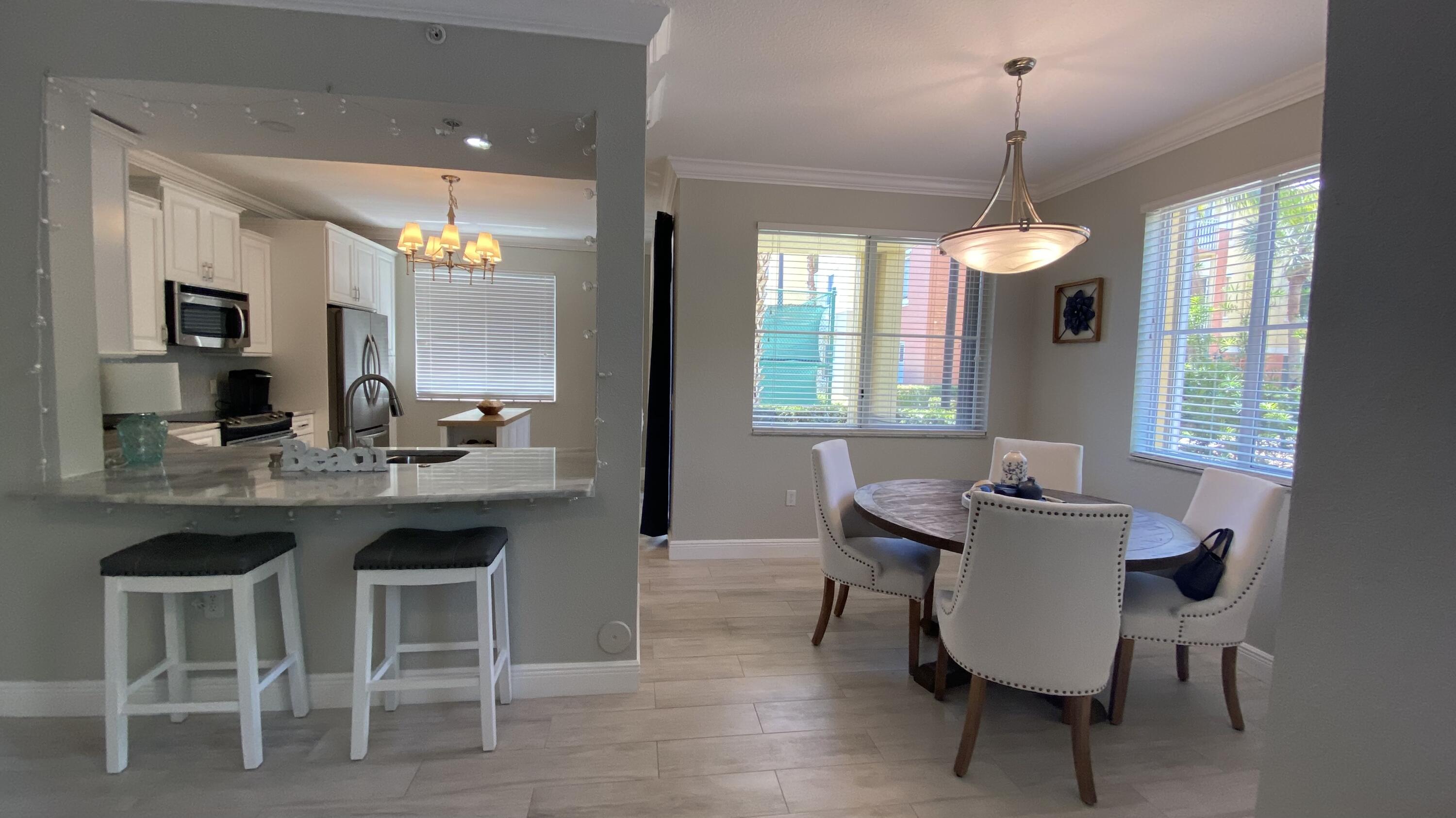 11024 Legacy Drive, Unit 104 Palm Beach Gardens, FL 33410 - Photo 5 of 26 a view of a dining room with furniture window and wooden floor