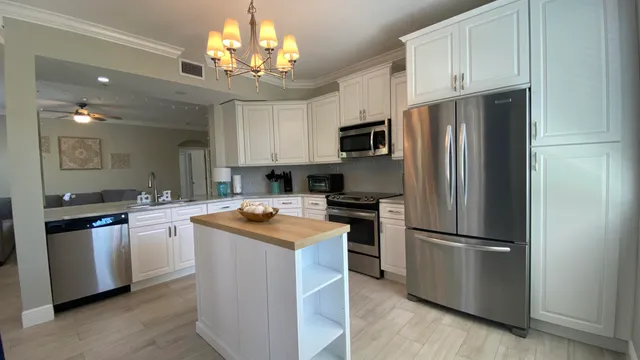 a kitchen with stainless steel appliances granite countertop a refrigerator a stove a sink and a refrigerator