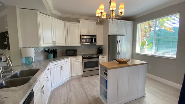 a kitchen with kitchen island granite countertop a sink stainless steel appliances and cabinets