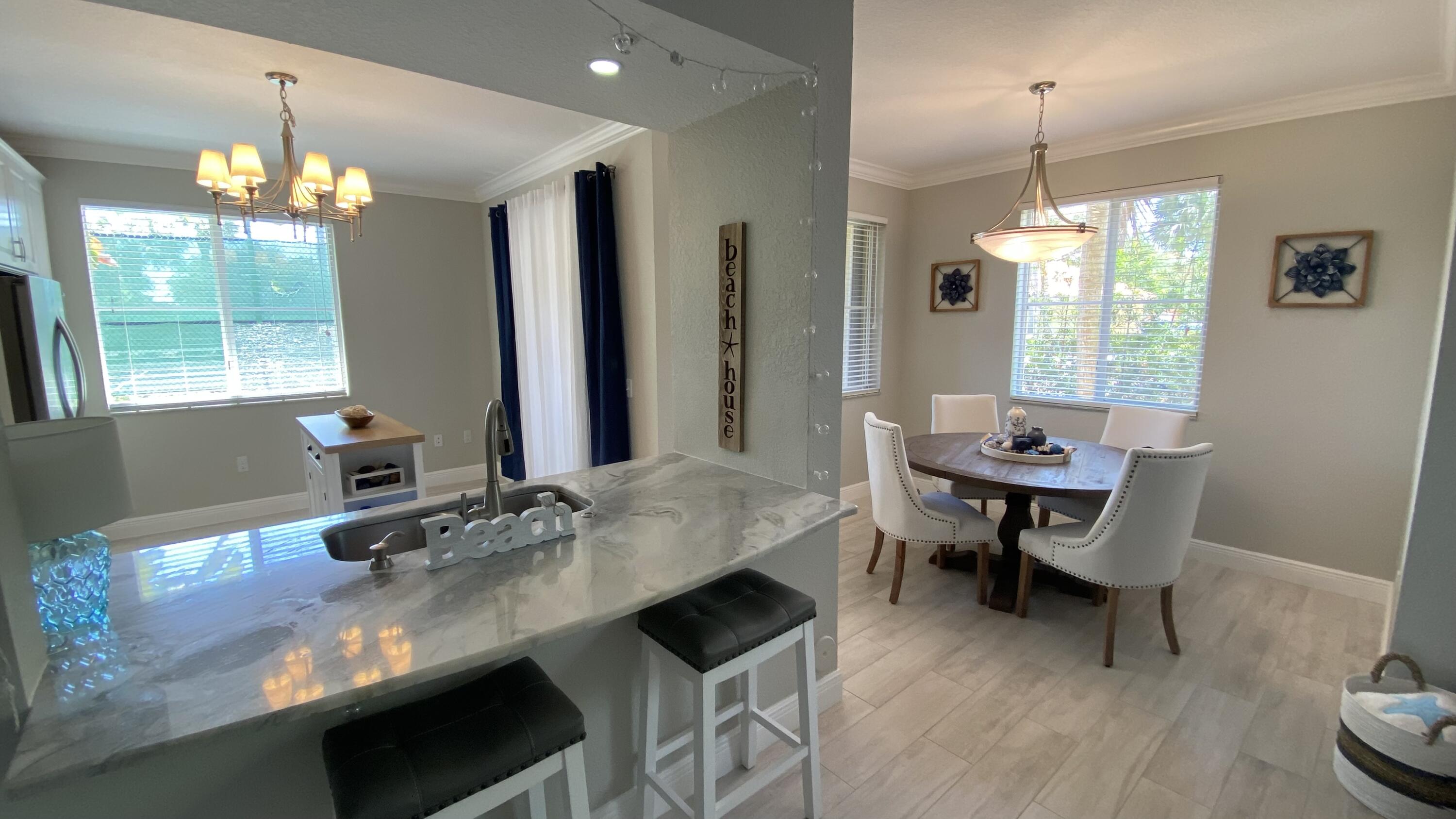 11024 Legacy Drive, Unit 104 Palm Beach Gardens, FL 33410 - Photo 10 of 26 a dining room with furniture a chandelier and window