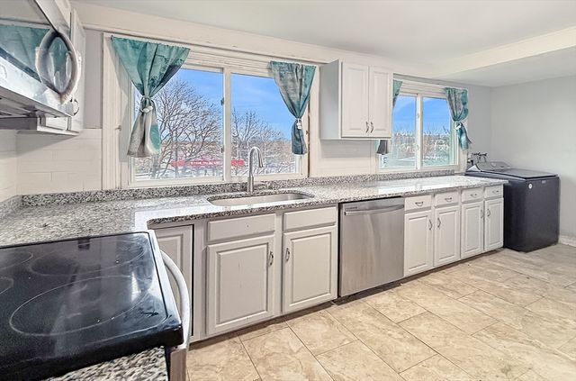 a kitchen with stainless steel appliances granite countertop a sink stove and cabinets