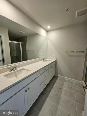 a spacious bathroom with a double vanity sink and a mirror