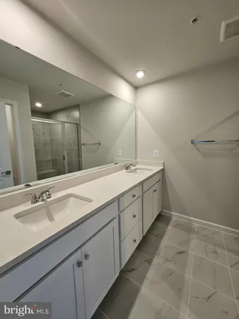 a spacious bathroom with a double vanity sink and a mirror