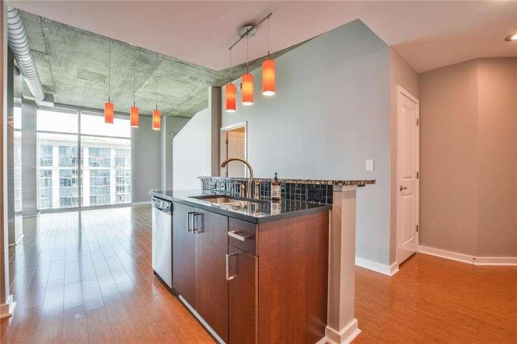 250 Pharr Road Northeast, Unit 2002 Atlanta, GA 30305 - Photo 2 of 13 a kitchen with stainless steel appliances granite countertop a stove and a wooden floors