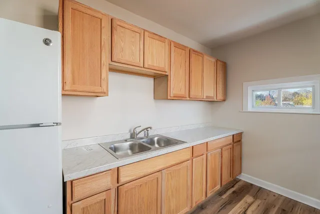 a kitchen with a sink cabinets and wooden floor