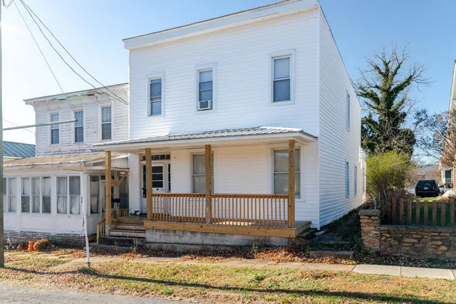 a front view of a house with a yard and potted plants