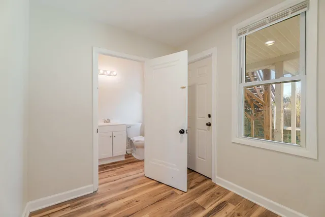 a view of a room with wooden floor and a bathroom