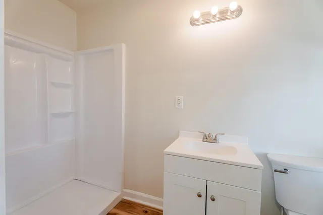 a bathroom with a sink a toilet and shower