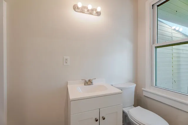 a bathroom with a sink mirror vanity and toilet