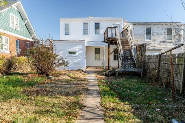 a view of a house with backyard and sitting area