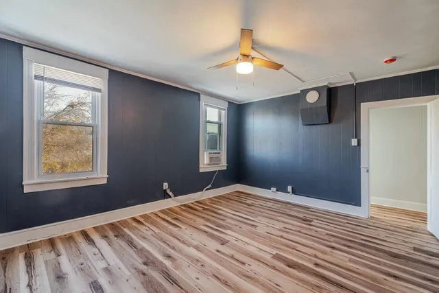 a view of empty room with wooden floor