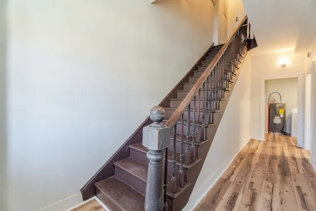 a view of a hallway with wooden floor and staircase