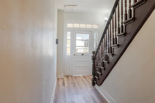 a view of hallway with stairs and wooden floor