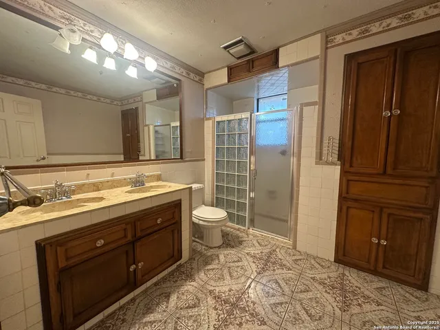 a bathroom with a granite countertop sink toilet and shower